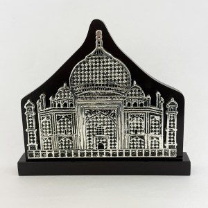 Taj Mahal–inspired embossed metal plaque on a black backdrop, mounted on a pedestal.