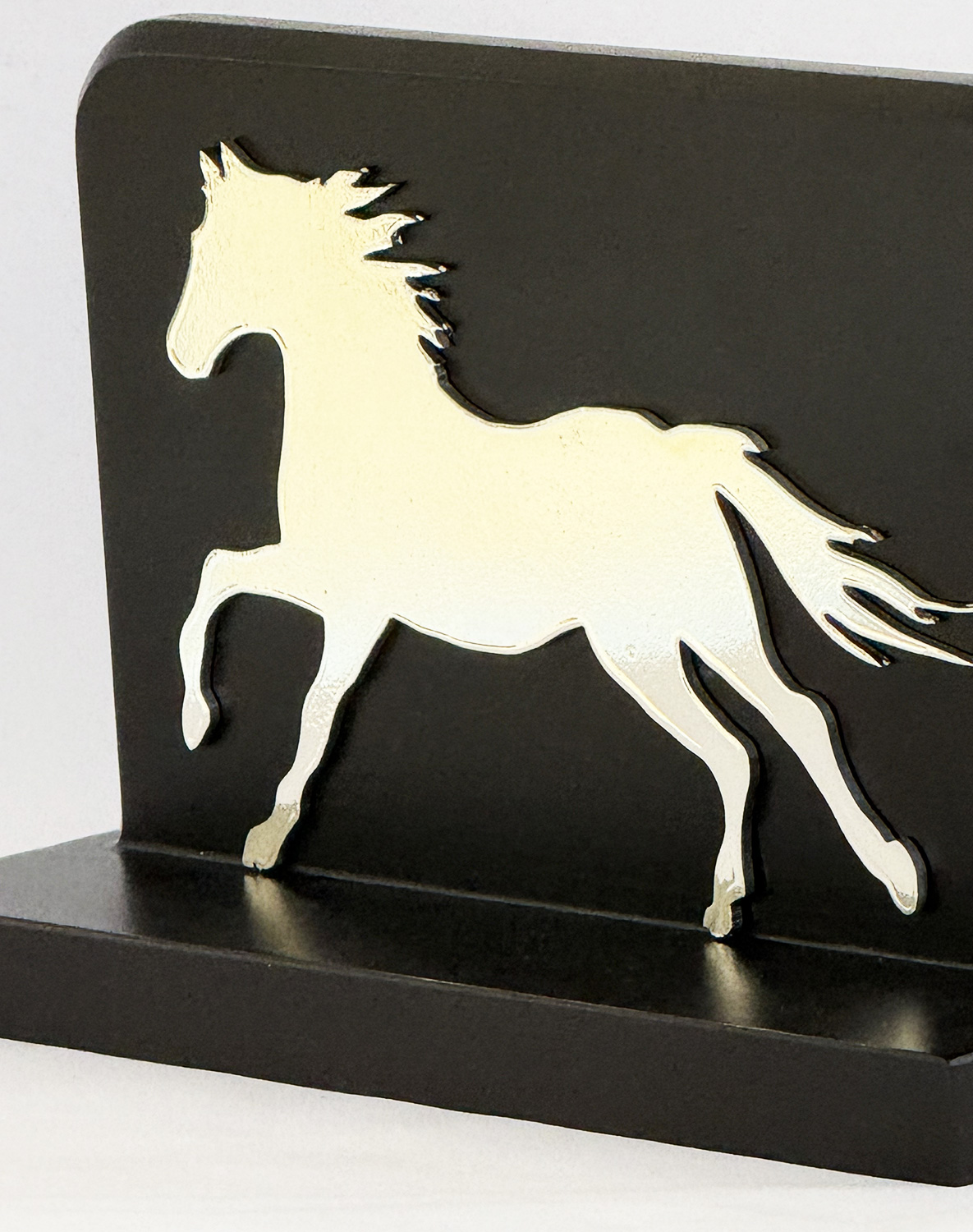 White horse silhouette cutout mounted on a black plaque/board for decorative display
