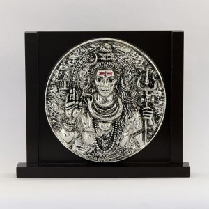 Silver-toned circular relief of Shiva as Nataraja with multiple arms and ornate halo, mounted on a black display stand.
