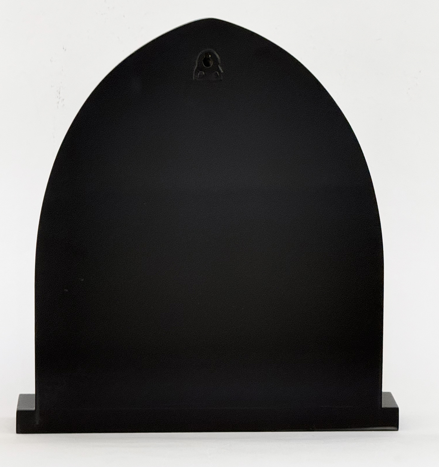 Abstract black curved sculpture mounted on a rectangular base against a pale backdrop.