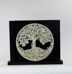 Round silver tree-of-life medallion mounted on a black display block, decorative art piece
