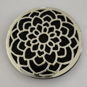 Round decorative metal lattice with floral pattern, silver outline and black background.