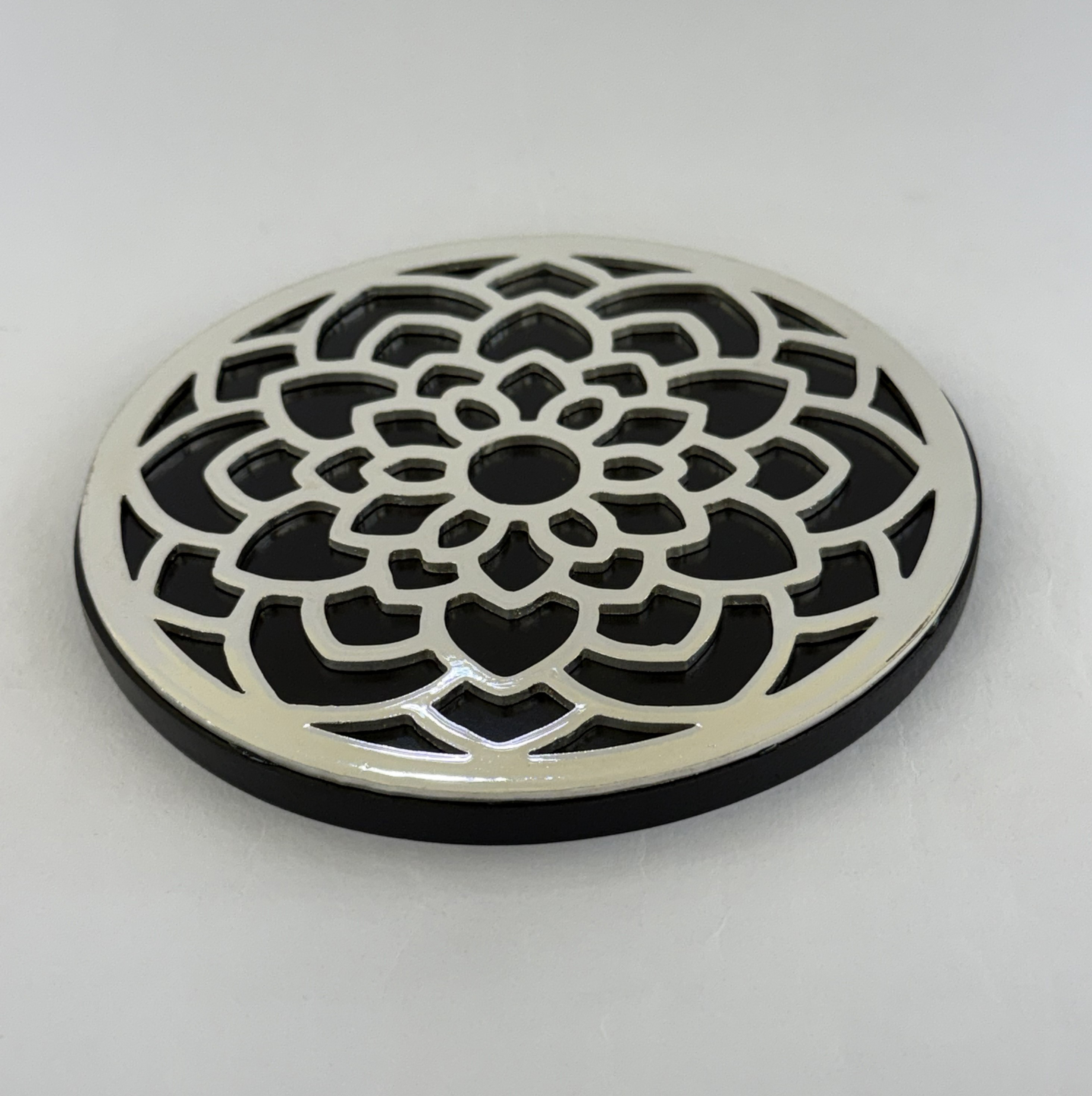 DX-CSA-2b Close-up of a white circular drain cover with a decorative lattice pattern on a light floor.