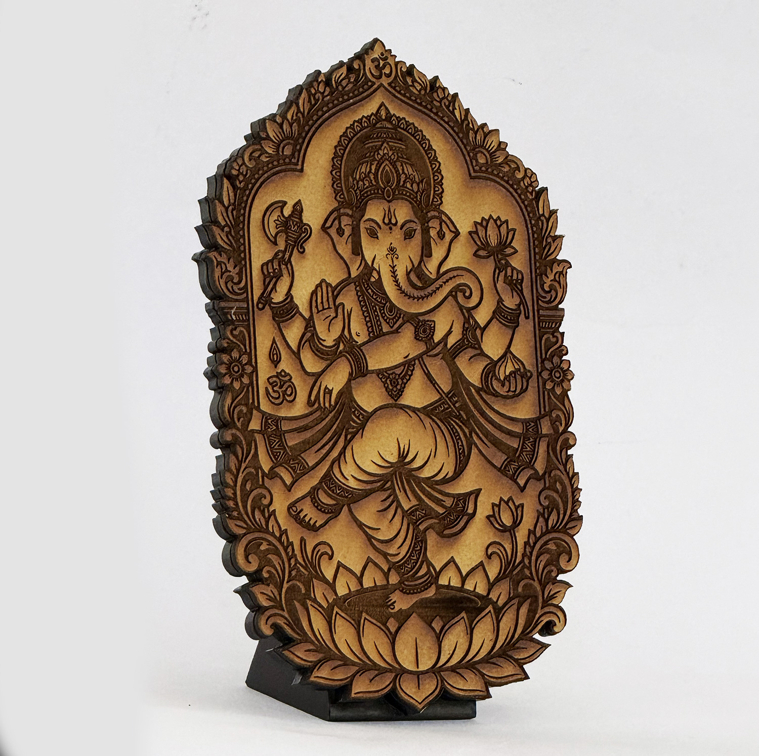 Carved wooden plaque of Ganesha, the elephant-headed deity, seated on a lotus and holding an axe and a lotus