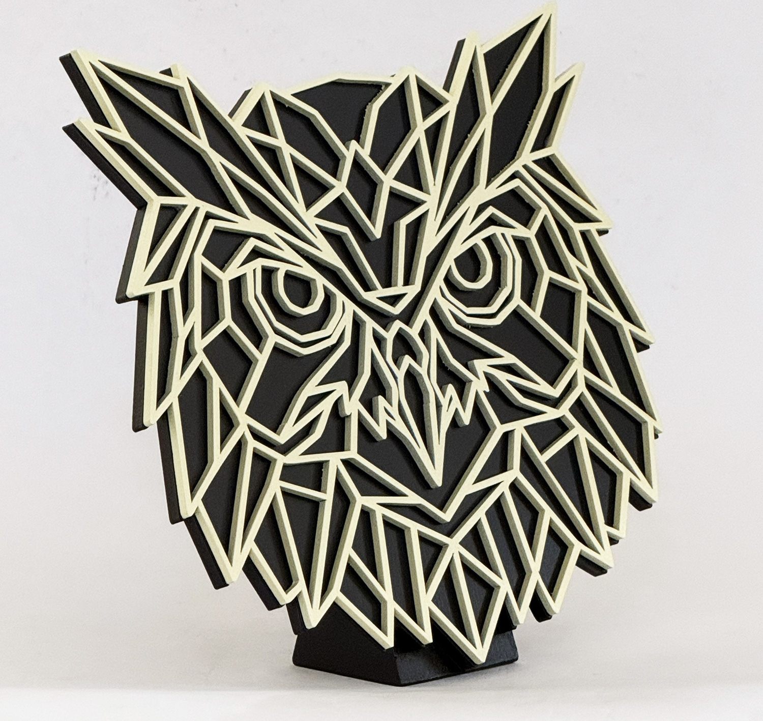 Abstract geometric sculpture of a wolf head made from cream lines on a black background, mounted on a small pedestal