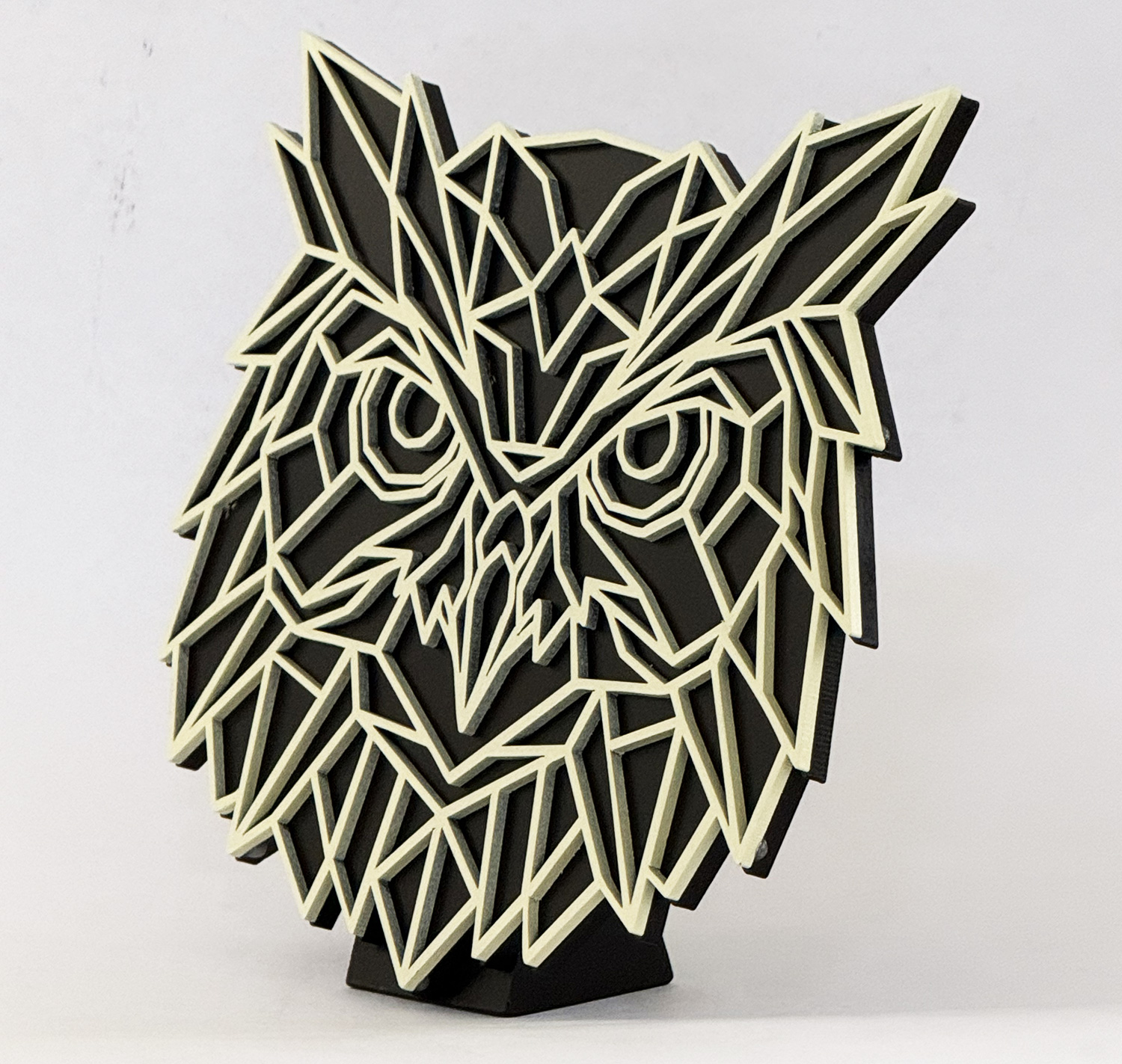 Geometric abstract lion head sculpture with white angular outlines on a black form, resting on a black base.