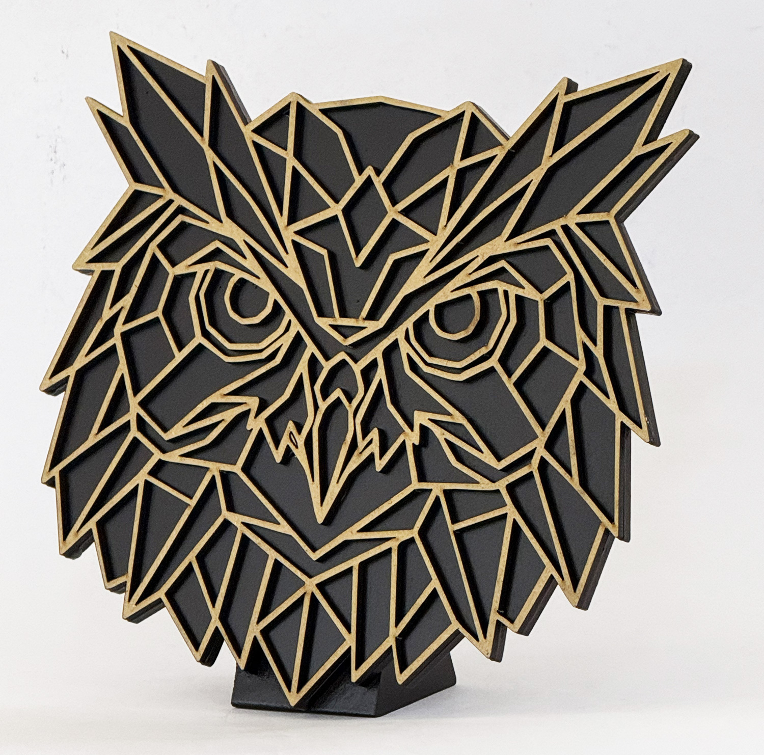 Abstract geometric fox head sculpture made of black panels with natural wood edges, mounted on a small black base.