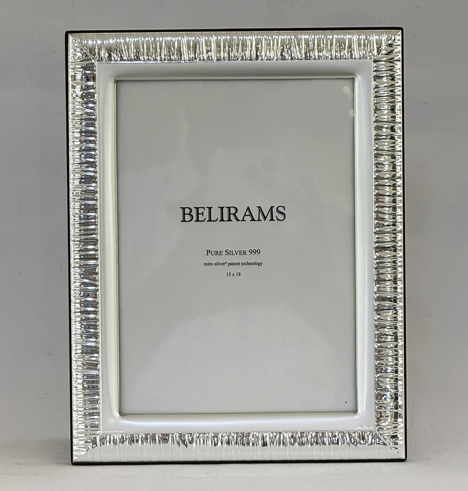 Silver rectangular picture frame with a textured metallic border and a label reading 'BELIRAMS' inside.