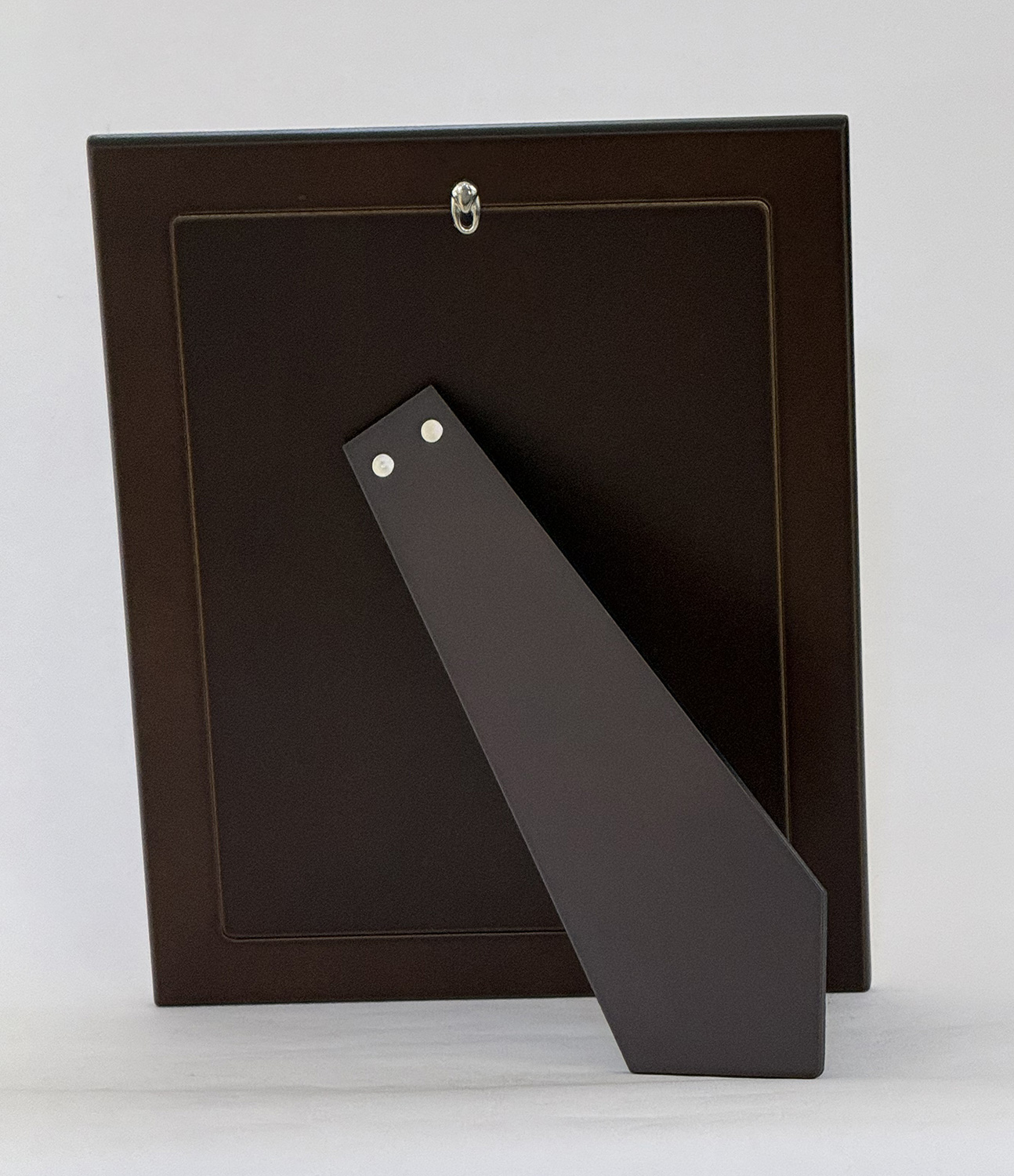 Back view of a dark brown picture frame with a metal easel stand attached for display