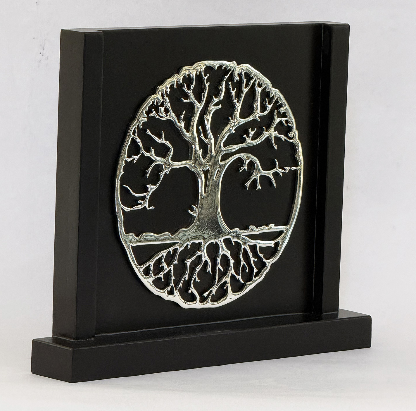 Metal tree of life sculpture mounted on a black display plaque on a pedestal